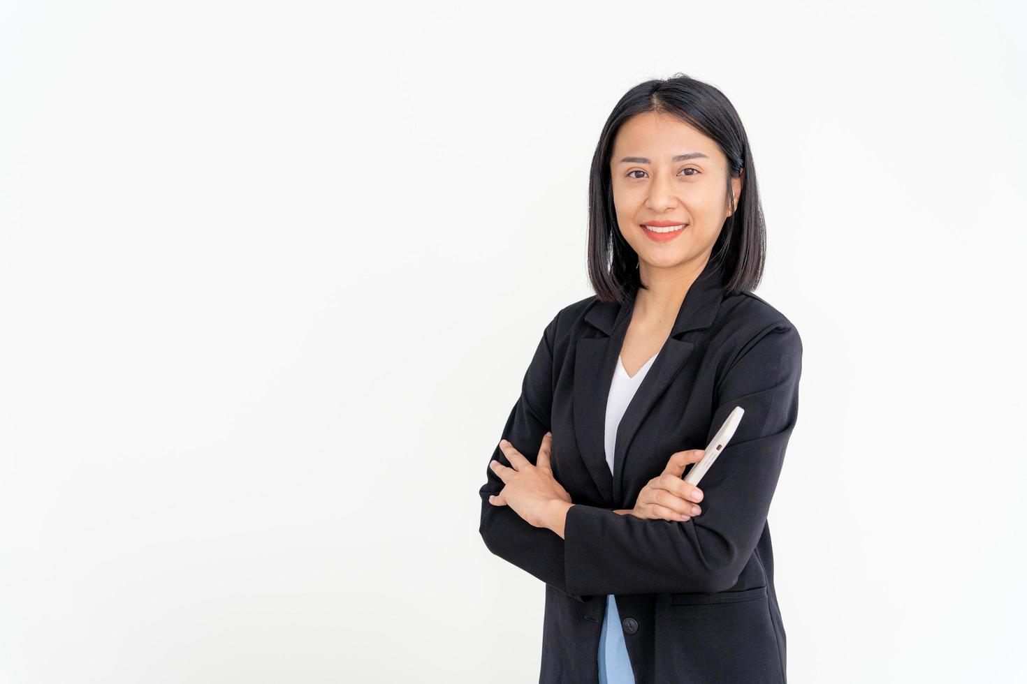 Aziatisch zakenvrouw glimlachen en Holding smartphone. mooi Aziatisch vrouw staand met gekruiste armen. vrouw portretten. bank personeel, accountant, administratie, officier foto