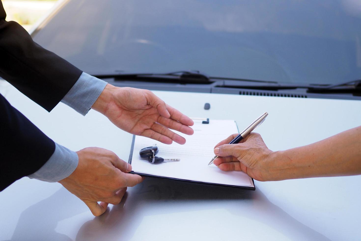teken de auto herfinanciering contract. lening bedrijf en lening vrijlating foto