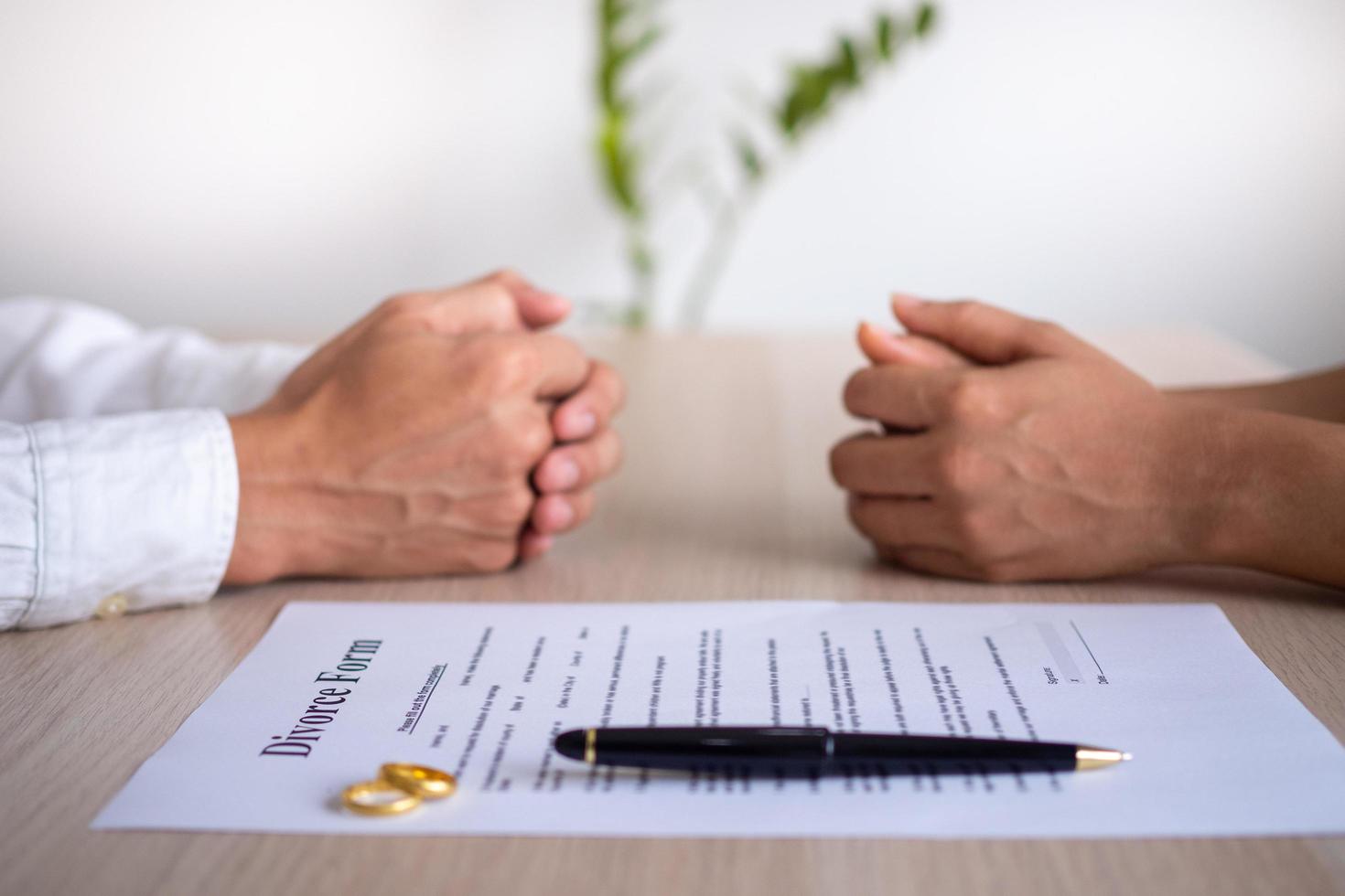 de handen van de vrouw en man met de bestellen van scheiding, ontbinding, annulering van huwelijk, wettelijk scheiding documenten, scheiden deponeringen of voorhuwelijks overeenkomsten bereid door een advocaat. foto