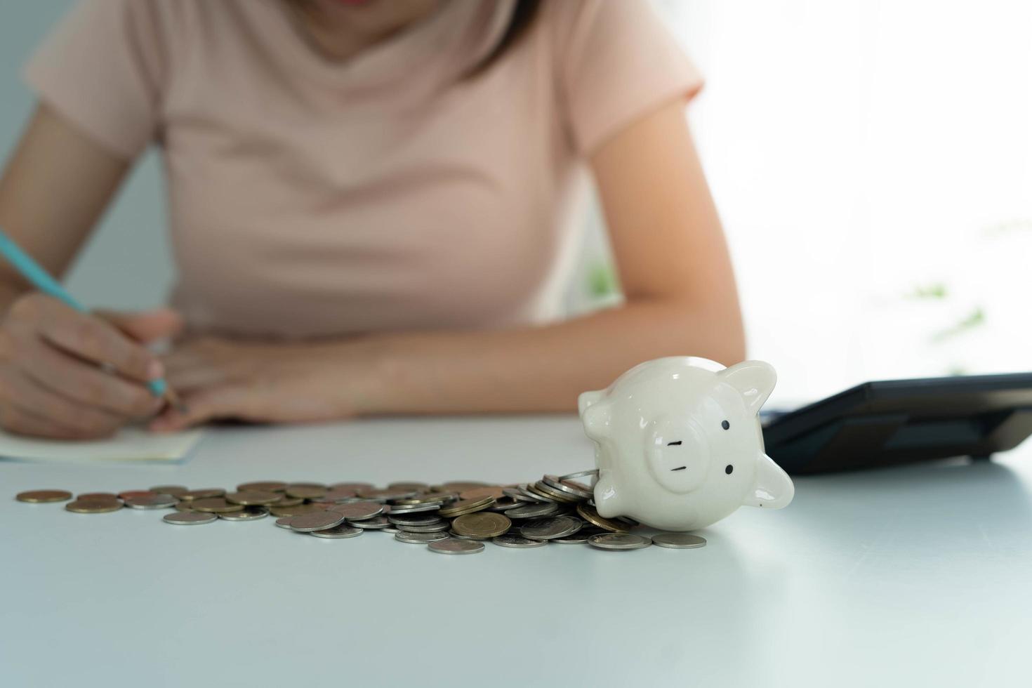 varkentje bank met een stapel van munten. Dames verschuldigd credit kaarten zijn berekenen allemaal onkosten en schulden. schuld concept foto