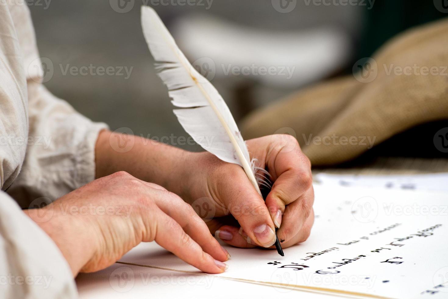 handen schrijven een brief met een pluim foto