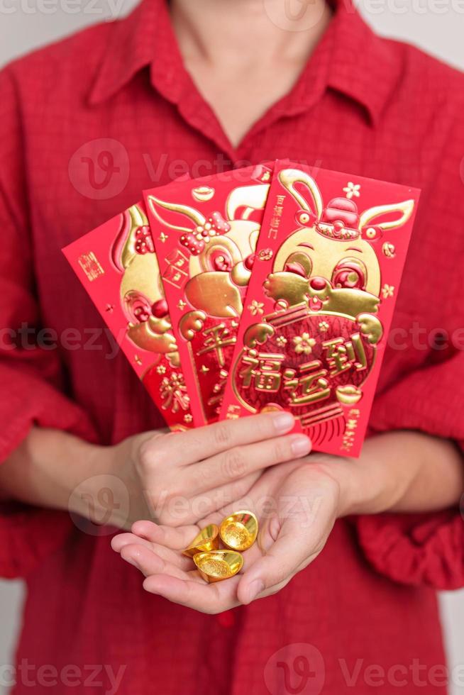 vrouw Holding Chinese rood envelop met goud edelmetaal, geld geschenk voor gelukkig maan- nieuw jaar vakantie. Chinese zin middelen geluk, gezond, Lucky en rijk foto