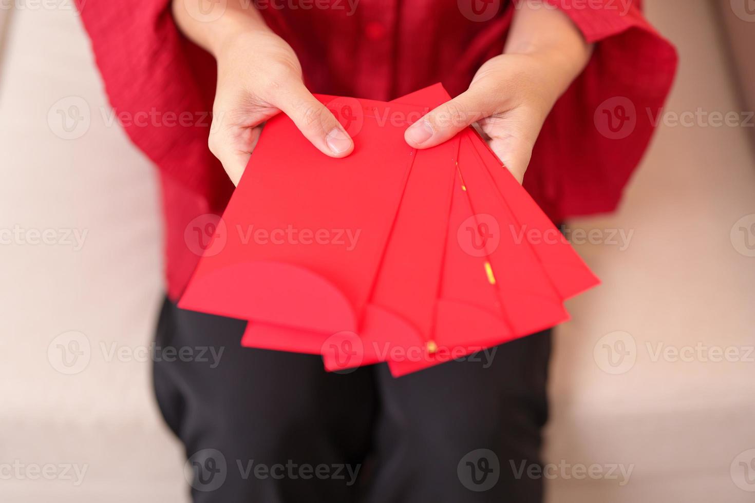 vrouw Holding Chinese rood envelop, geld geschenk voor gelukkig maan- nieuw jaar vakantie foto