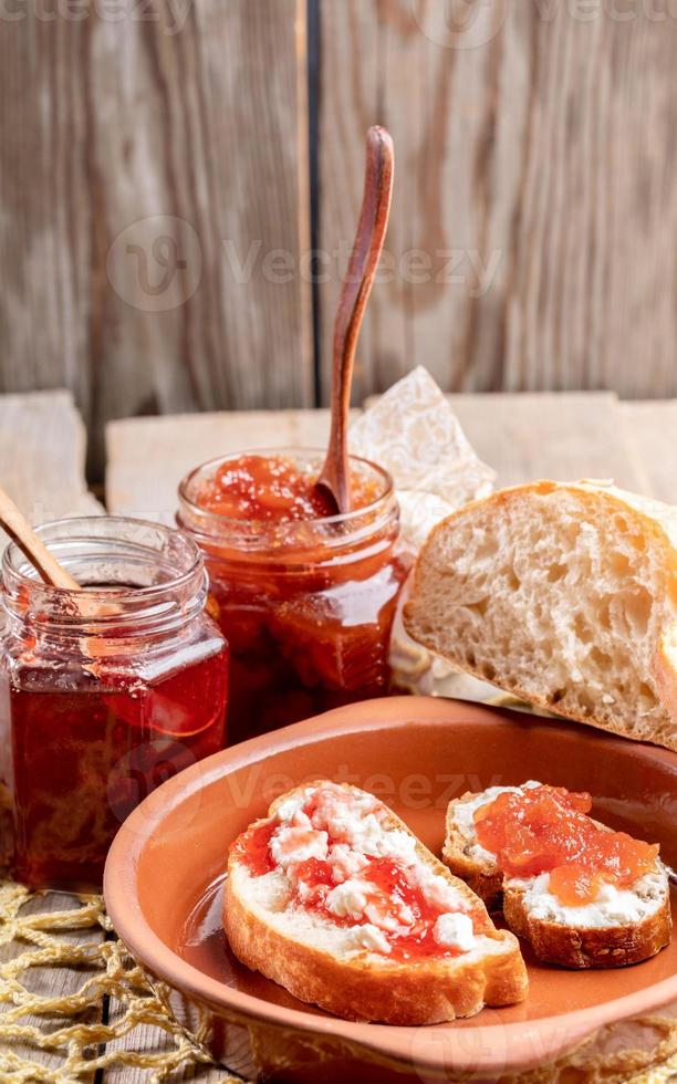 ontbijt tafel met toast met wrongel en zoet aardbei en appel jam Aan rustiek houten achtergrond. foto