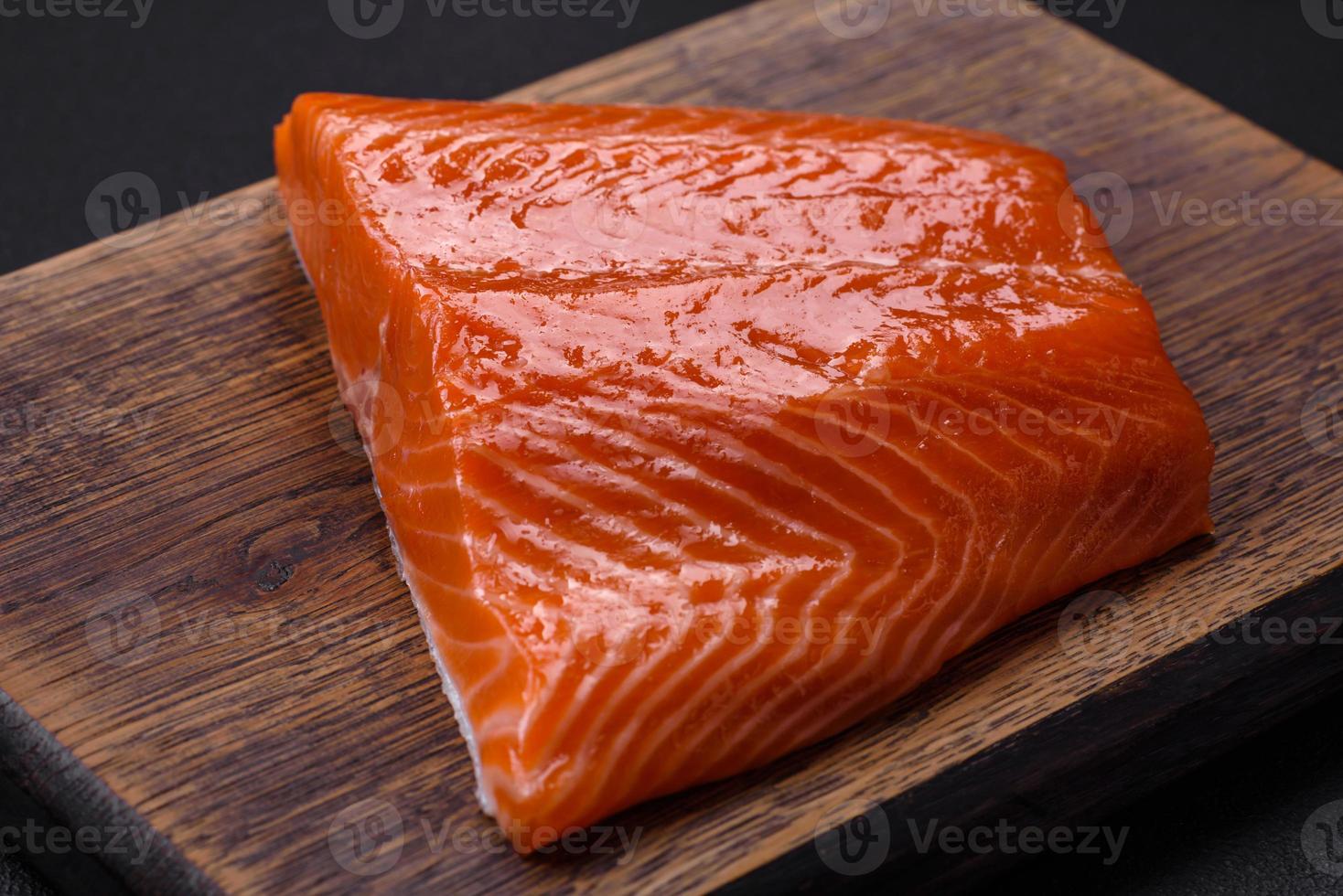 filet van rauw rood Zalm vis met zout, specerijen en kruiden foto