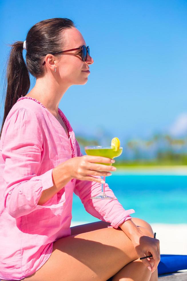 vrouw met een cocktail op het strand foto