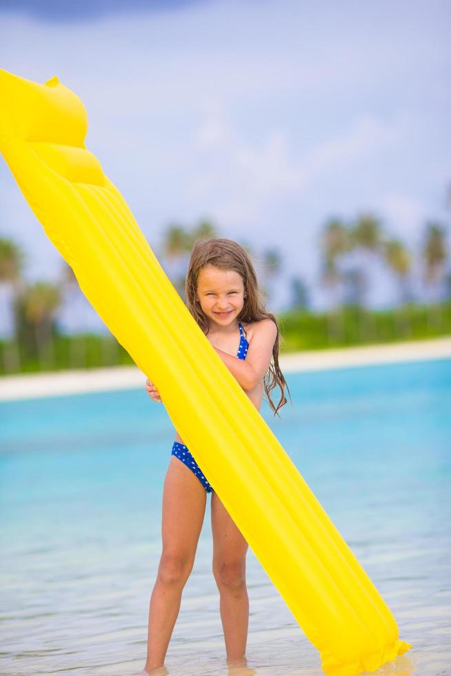 meisje met een floatie vlakbij het strand foto