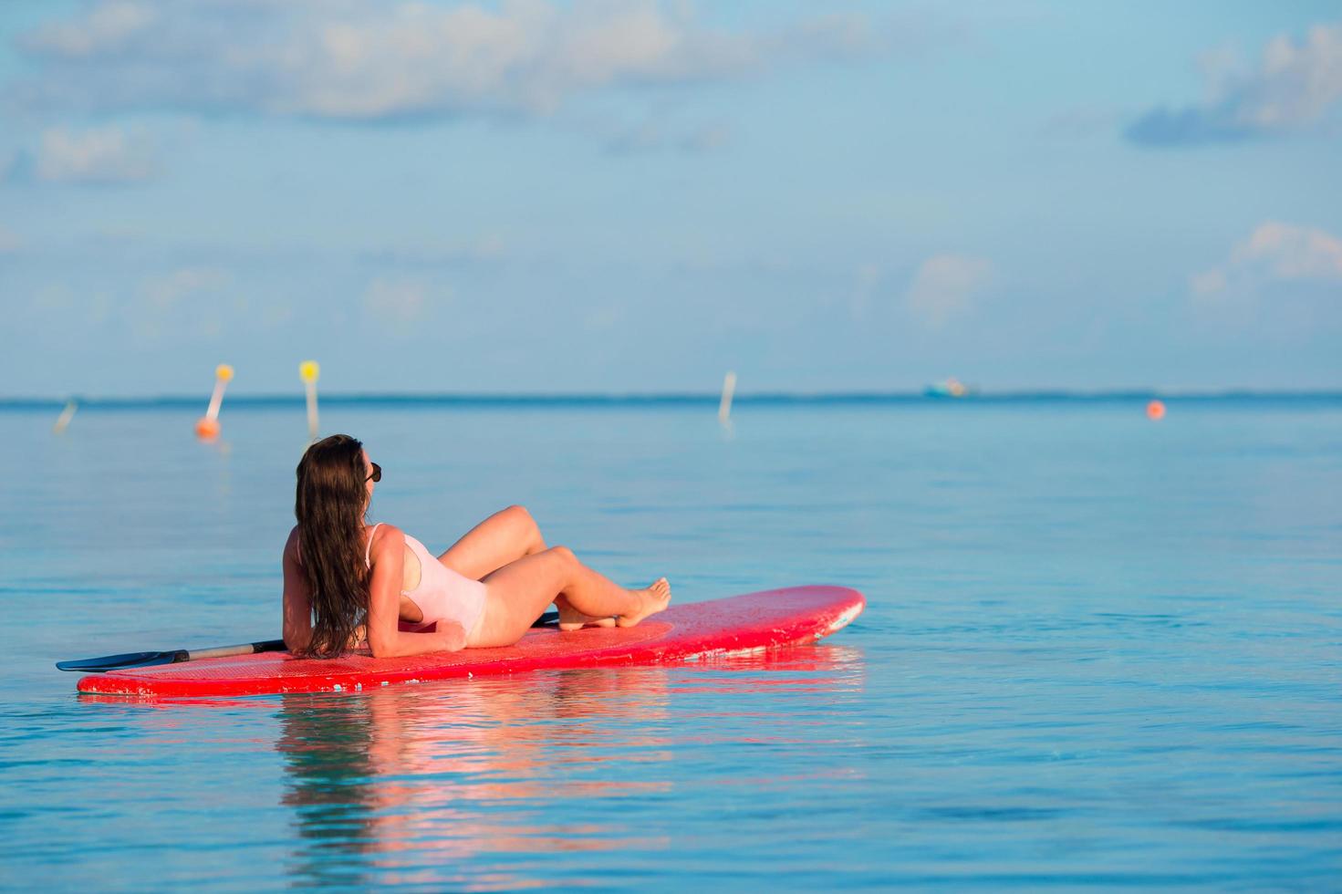 vrouw ontspannen op een surfplank foto