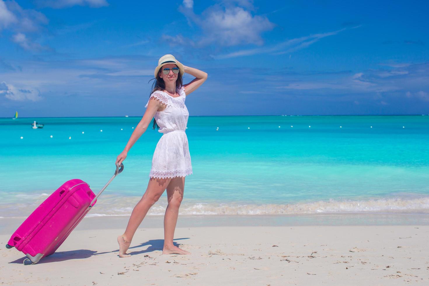 vrouw lopen met haar tas op een tropisch strand foto