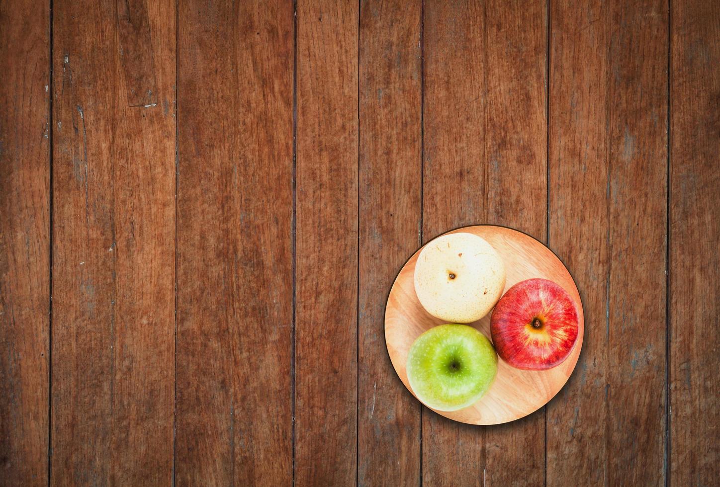 bovenaanzicht van drie appels op een houten achtergrond foto