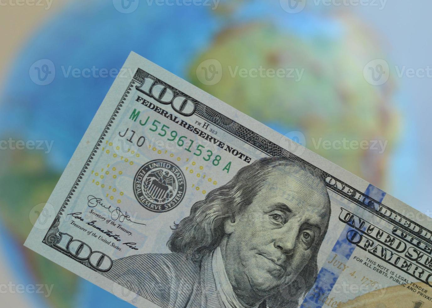 detailopname van een dollar Bill tegen de achtergrond van een wereldbol. de concept van globalisering van de wereld economie en de creatie van een single valuta ruimte. foto