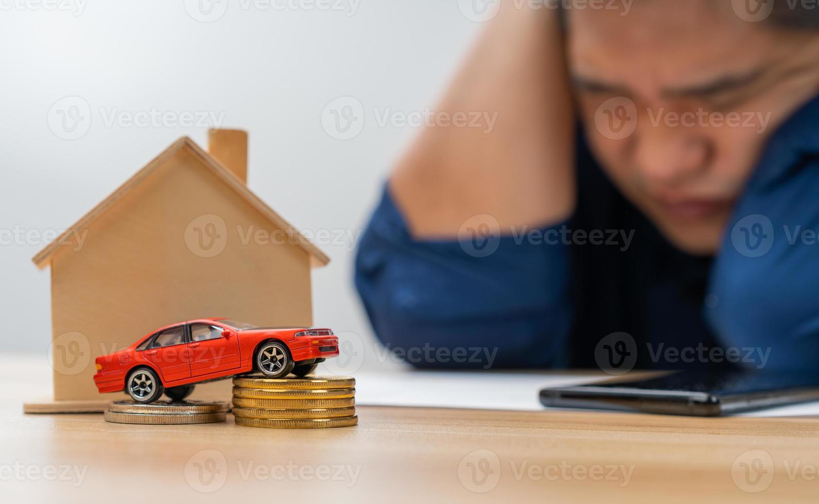 ongelukkig Aziatisch Mens Holding een bankbiljet en maken een account van inkomen en onkosten naar betalen de huis lening en auto lening, concept lening betaling en huis verzekering, economisch problemen, en inflatie foto