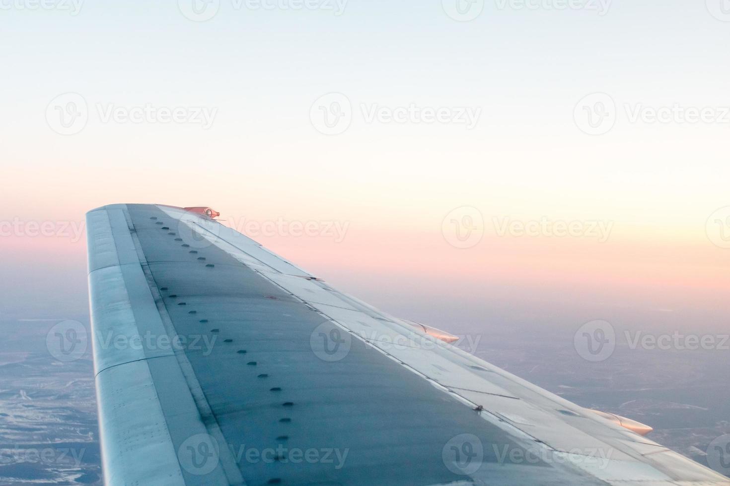 roze zonsondergang van bovenstaande, over- winter terrein en vliegtuig vleugel foto
