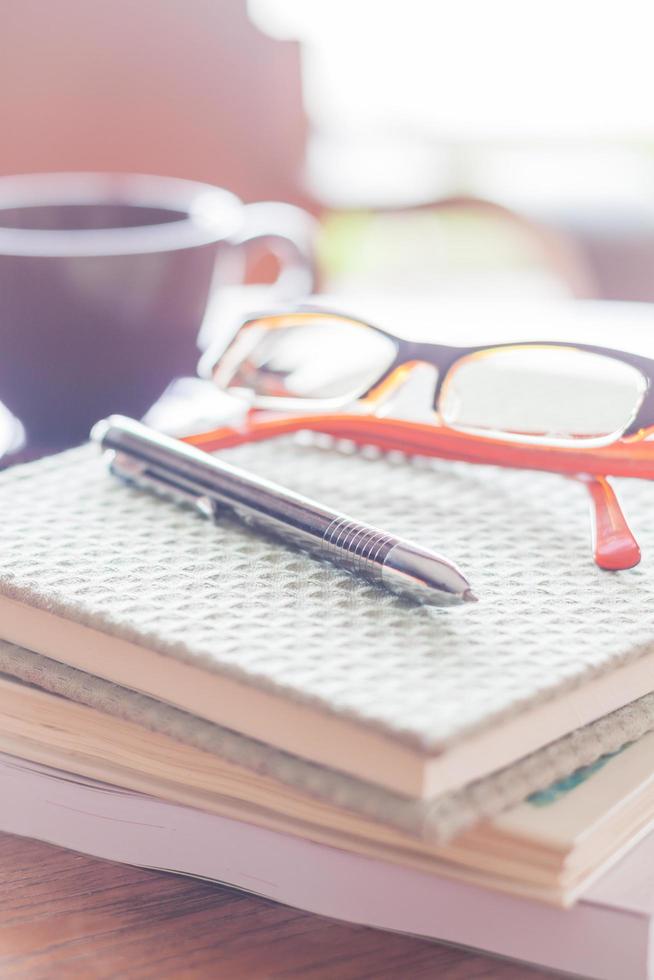 pen en bril op een notitieblok in een coffeeshop foto