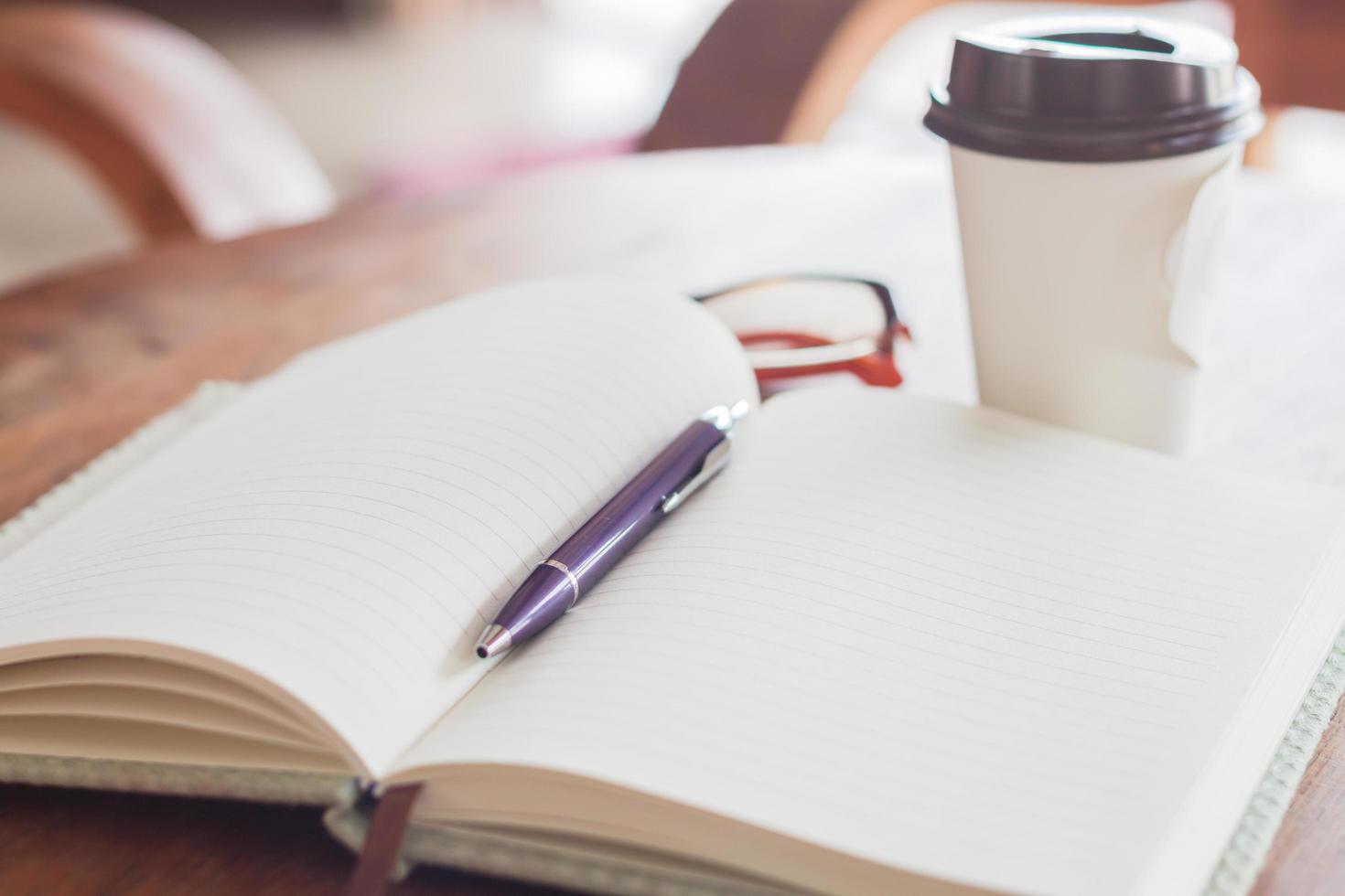 notitieboekje en pen met een koffiekopje foto