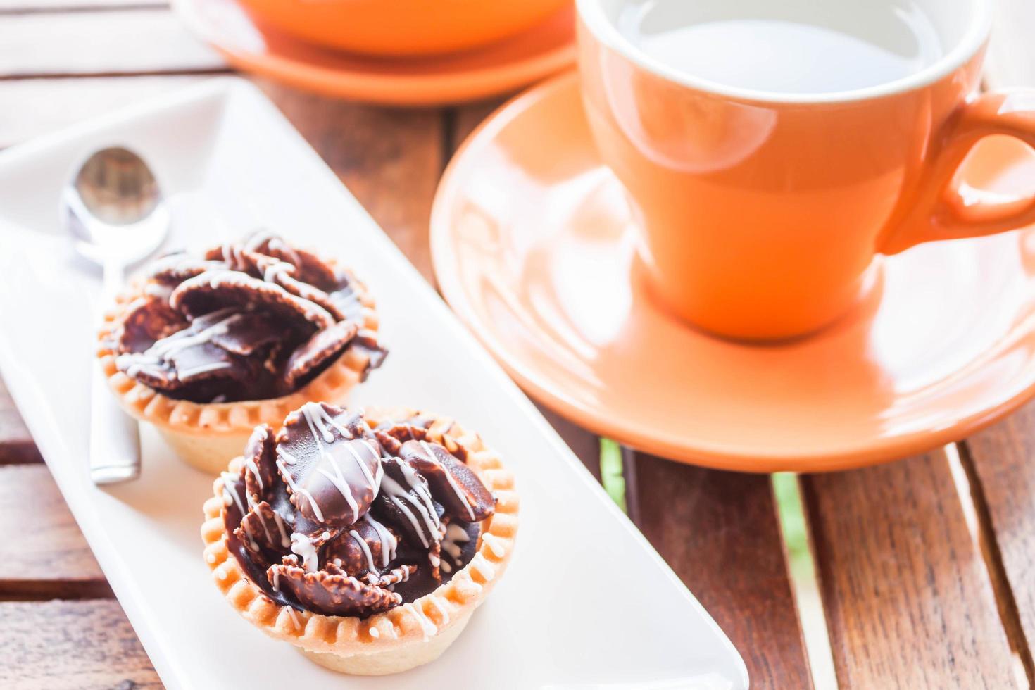 chocolade cupcakes en een oranje mok foto