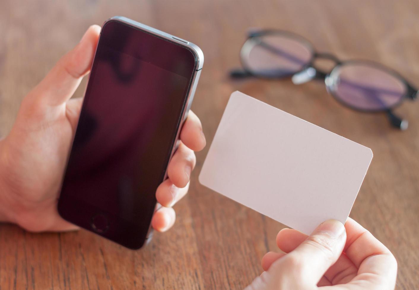 persoon met een lege telefoon en een visitekaartje foto