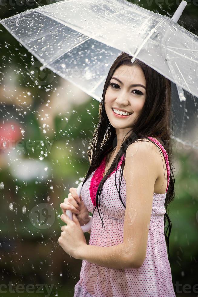 mooi meisje in de regen met transparant paraplu foto