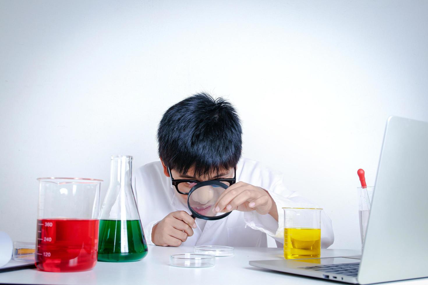 elementair school- jongen vervelend wit jurk, aan het doen wetenschappelijk experimenten in de laboratorium. concepten van kind onderwijs ontwikkeling foto