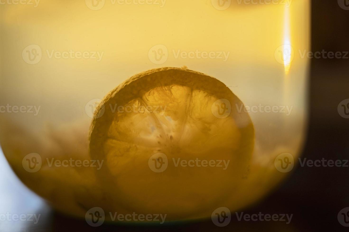citroen plak in appel compote in een glas pot Aan de tafel, zacht avond licht foto