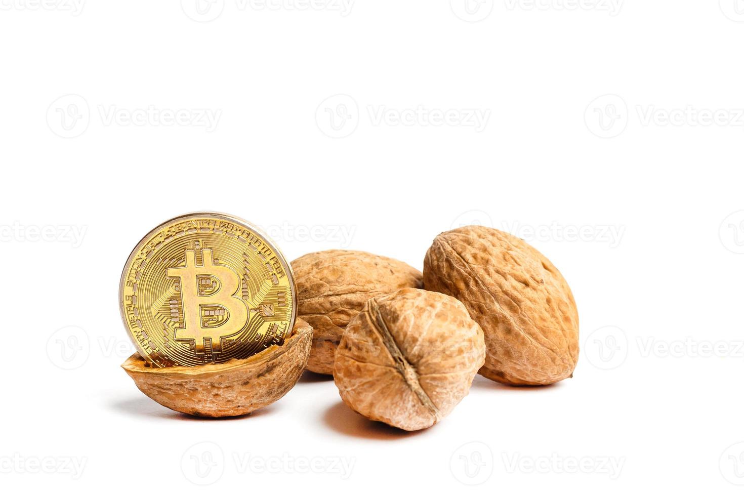 cryptogeld fysiek goud bitcoin munt in pistachenoten walnoten wit geïsoleerd foto