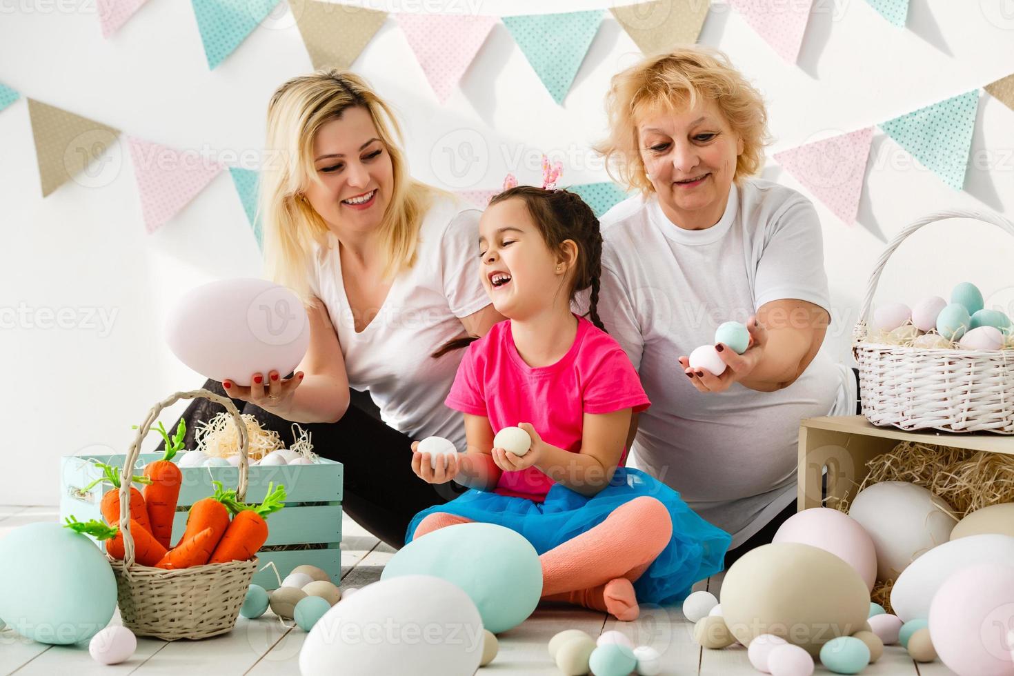 gelukkig familie met Pasen eieren. gelukkig kleintje meisje en grootmoeder met Pasen eieren foto