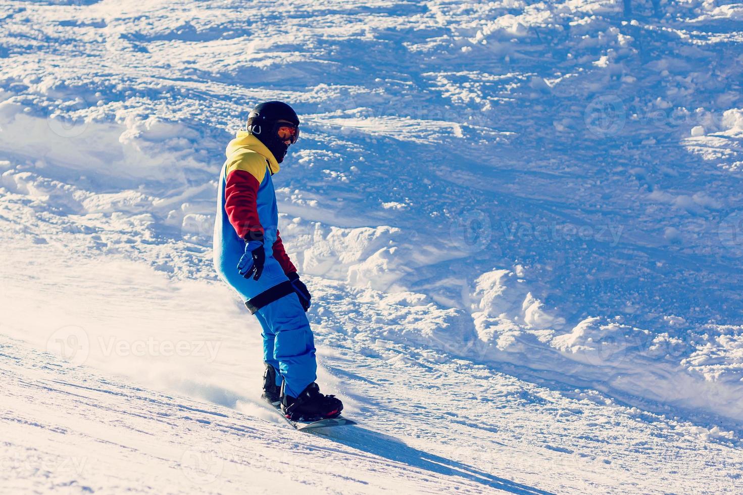 snowboarder die een teenkant doet snijden met diepe blauwe hemel op achtergrond foto