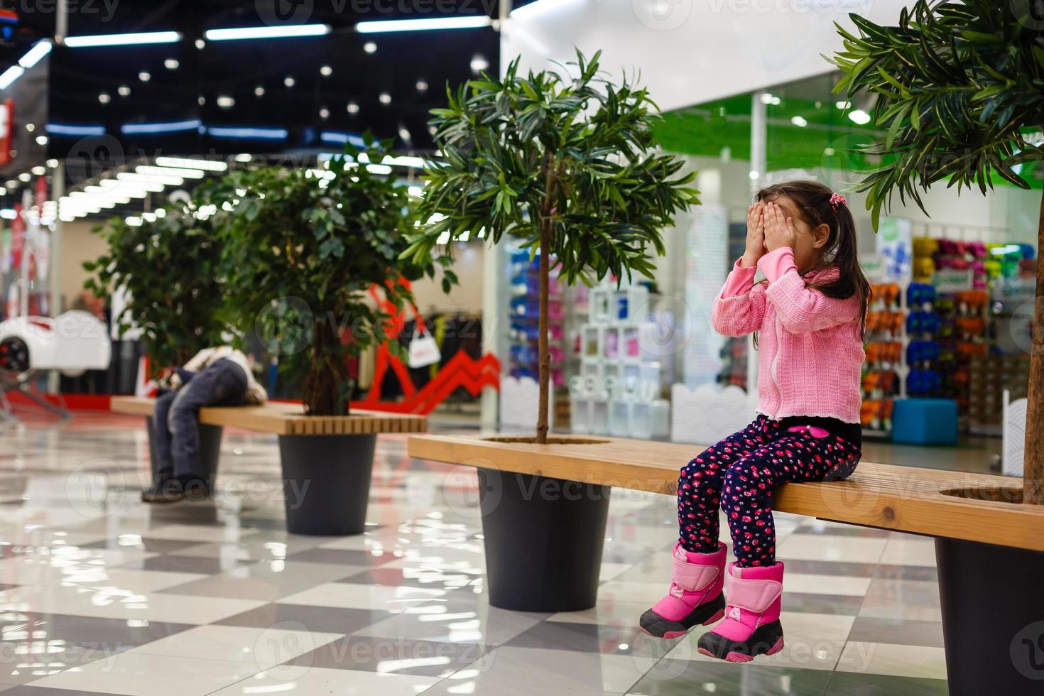 aanbiddelijk weinig meisje is huilen in de winkelcentrum foto