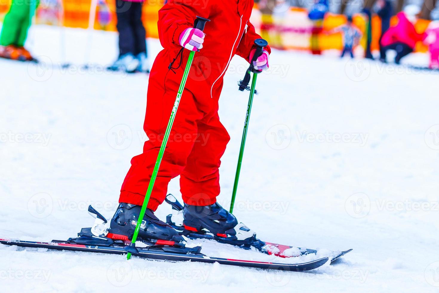 weinig meisje skiën bergafwaarts in winter uitrusting foto
