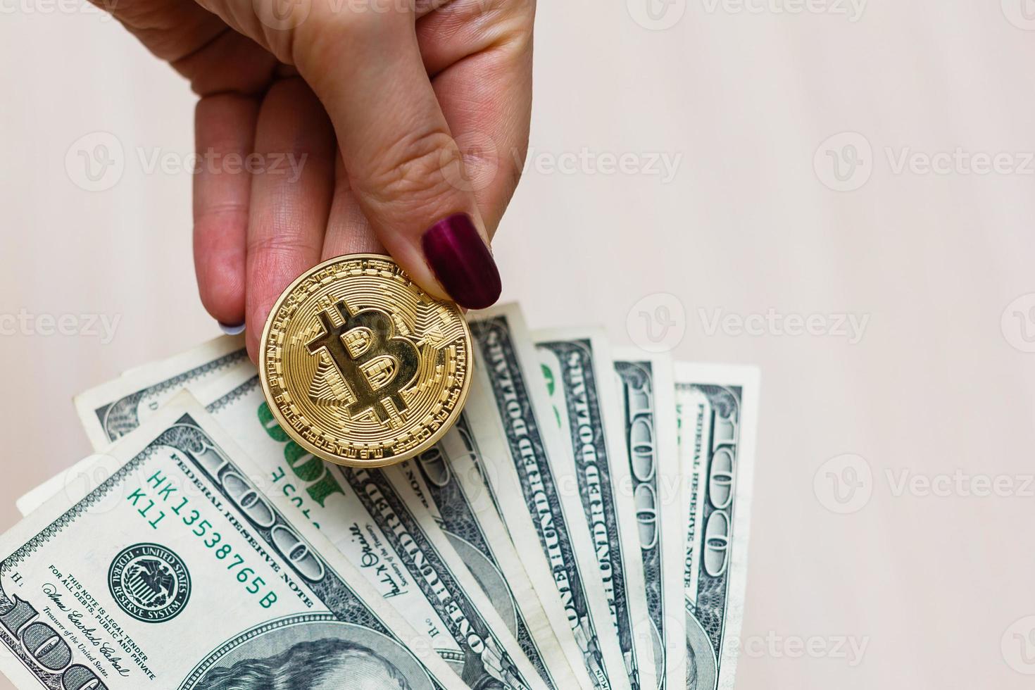 gouden bitcoin munt Aan vrouwen hand- Aan wazig ons dollar rekeningen achtergrond kopiëren ruimte foto