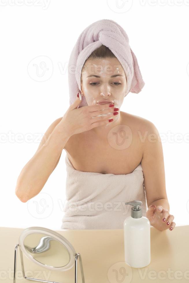 vrouw schoonmaak verwijderen bedenken van haar gezicht met een nat servet foto