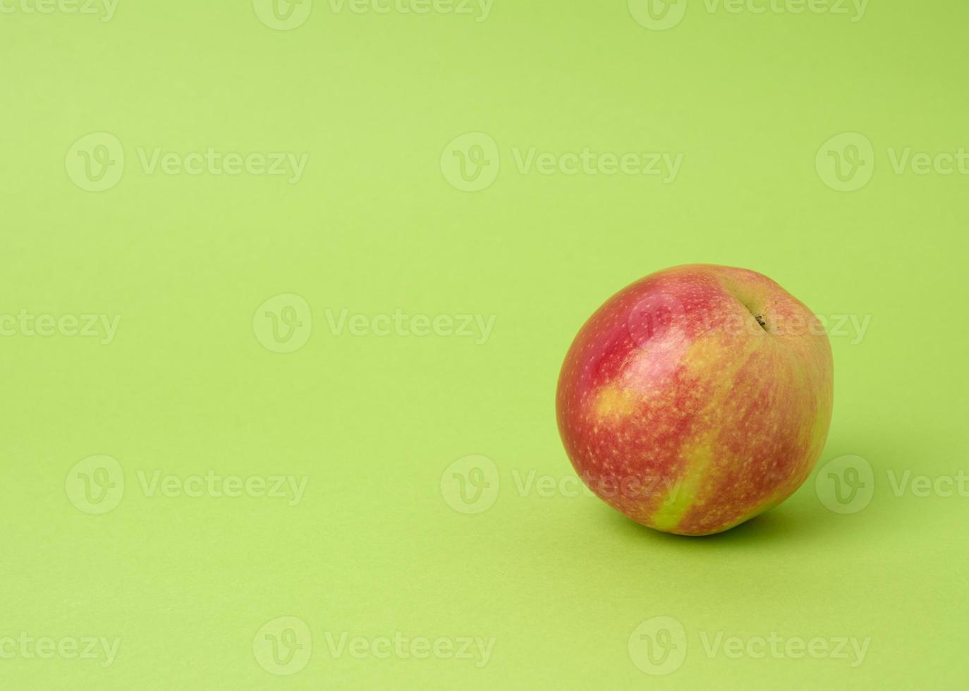 rijp rood ronde appel Aan een groen achtergrond, herfst oogst, dichtbij omhoog foto