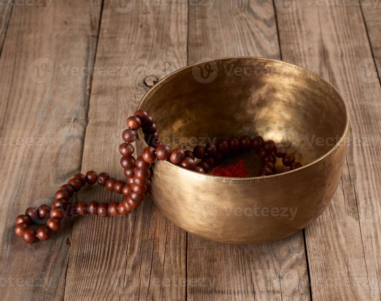 Tibetaans het zingen koper kom met een houten klepel Aan een bruin houten tafel foto