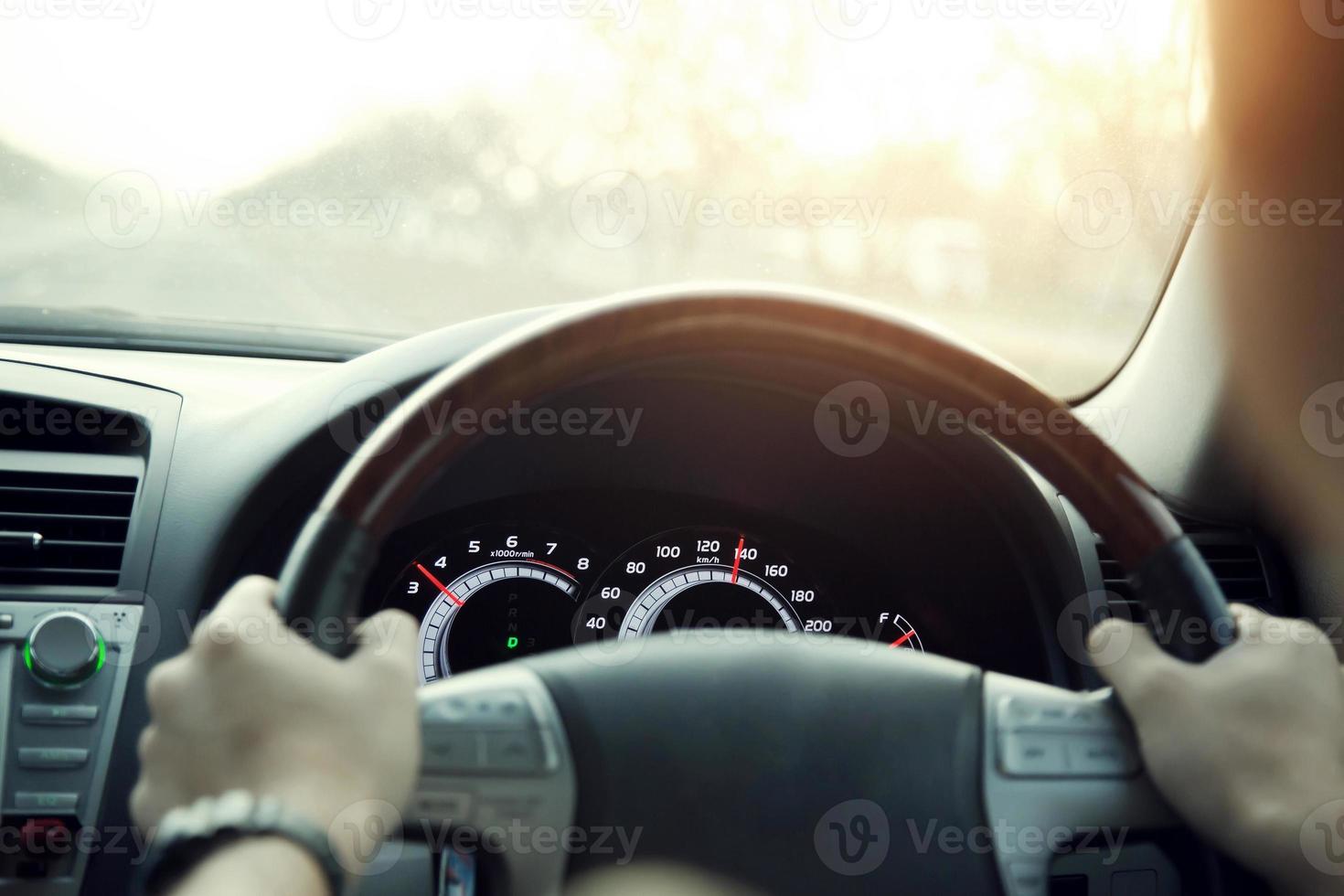 close-up van handen houden stuurwiel jonge man besturen van een auto rijden op de weg. chauffeur reis van reizen. foto