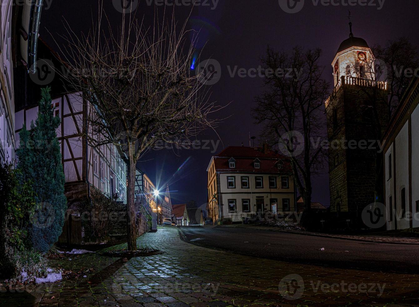 nacht tafereel van een oud Duitse stad- met studiewerk huizen en geplaveid straat in nat weer foto