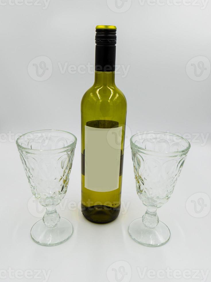 wijn fles en bril met leeg etiket voor zelf ontwerp foto