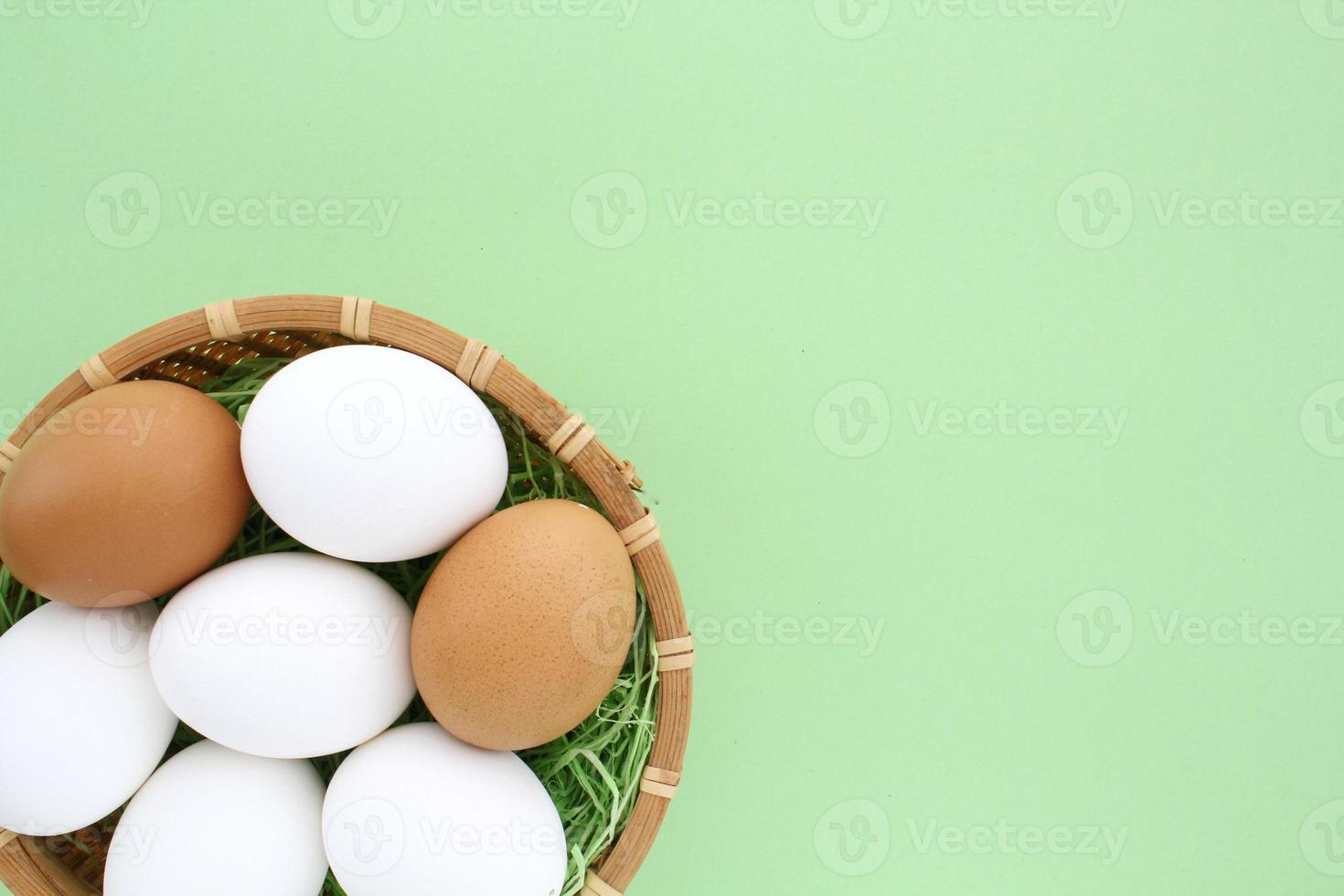 vers kip eieren in houten rotan rieten mand Aan groen achtergrond. natuurlijk gezond voeding biologisch boerderij voedsel Product concept. wereld ei dag, Pasen vakantie samenstelling. detailopname, flatlay foto