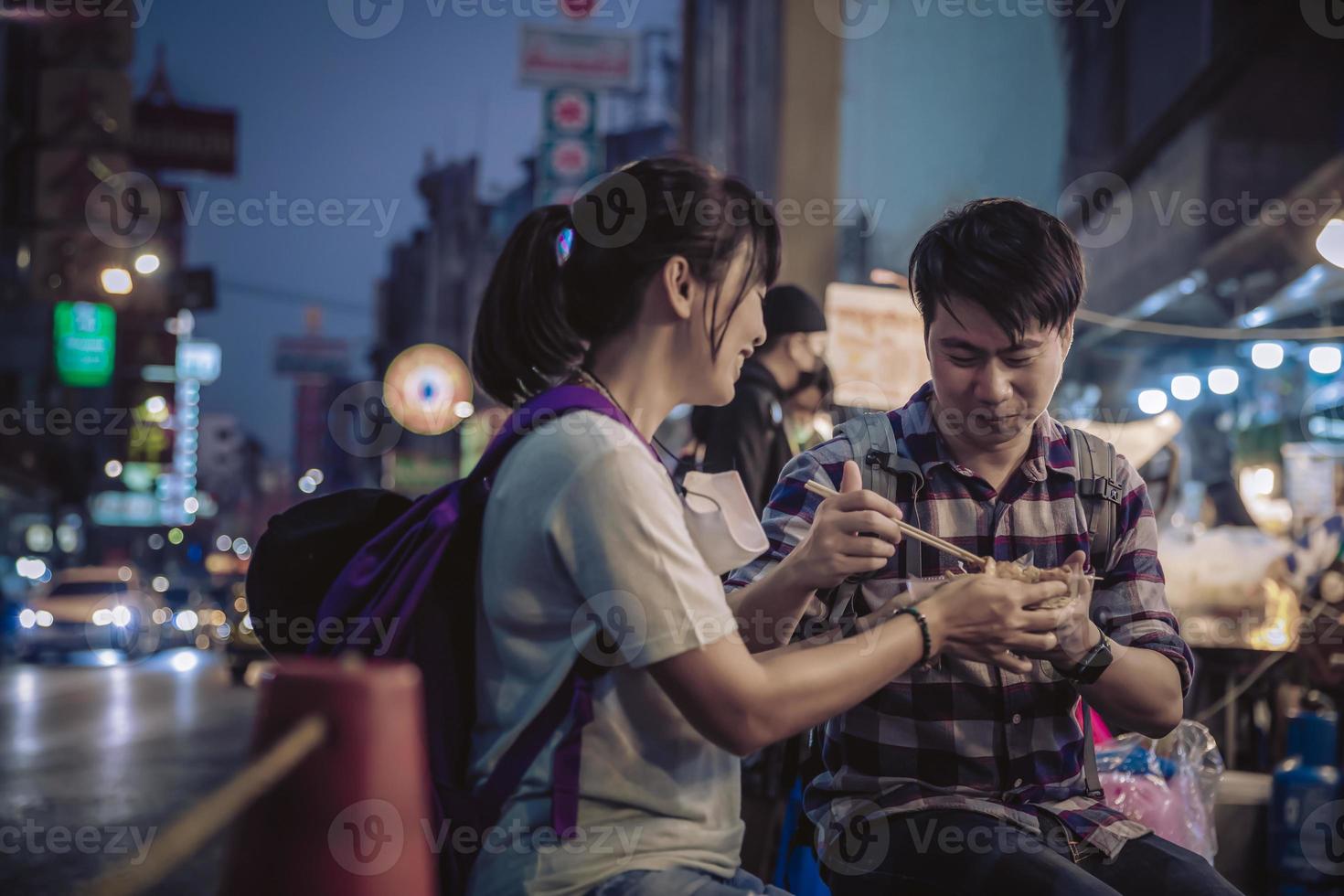 Aziatisch paar aan het eten in straat voedsel nacht markt voor toerist Aan Chinatown Bij yaowarat weg in Bangkok foto