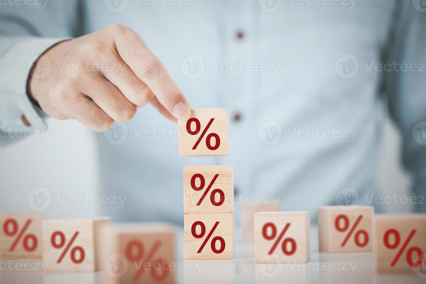 bedrijf Mens kiest een hout kubus blok Aan top met procent symbool icoon , concept van financieel , interesseren tarief en hypotheek tarieven foto