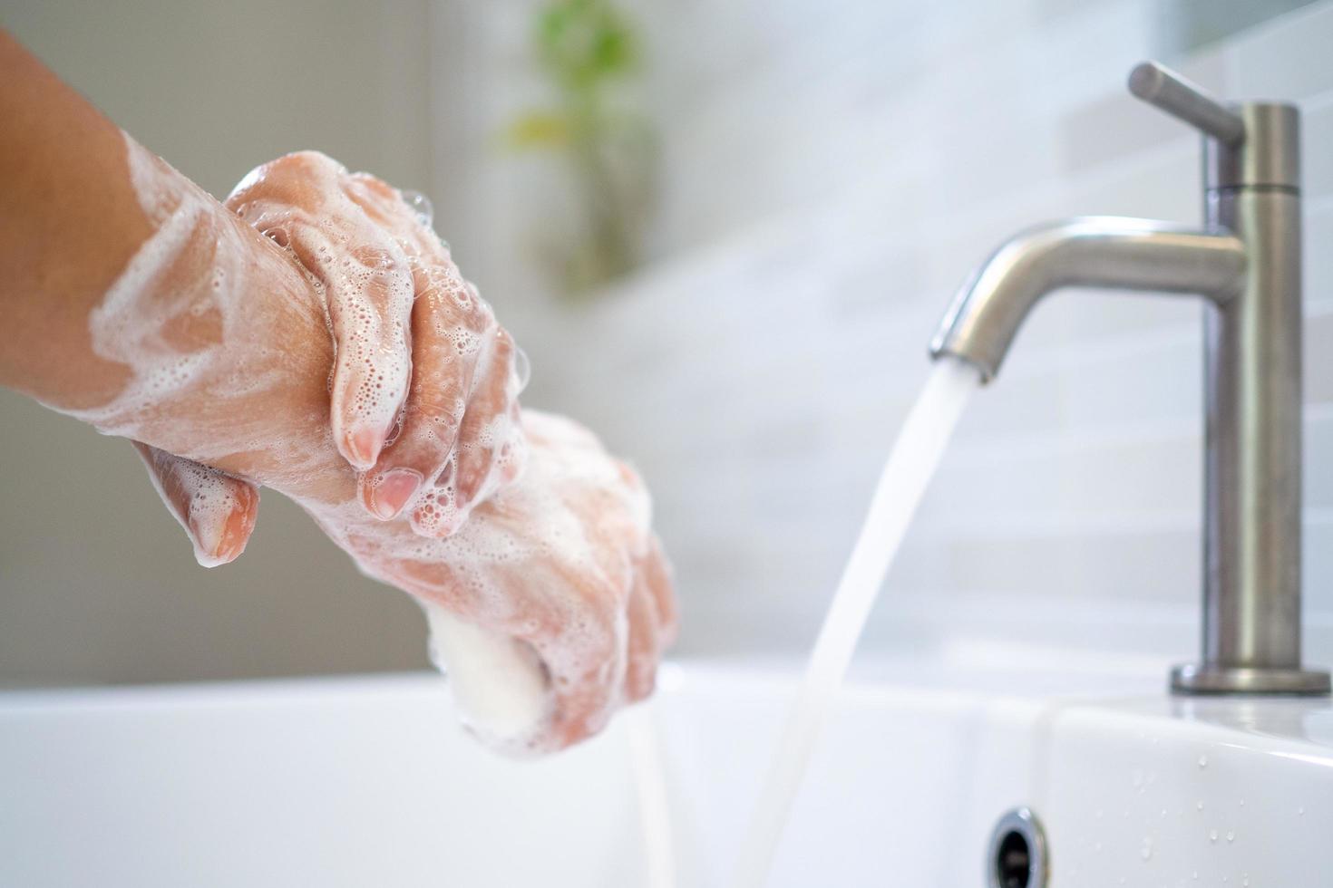 het wassen handen met zeep en water. Dames schrobben hand- zeep met wassen bekken .de concept van hand- hygiëne en hand- het wassen dagen in de omgeving van de wereld. verminderen de accumulatie van bacterie en virussen. foto