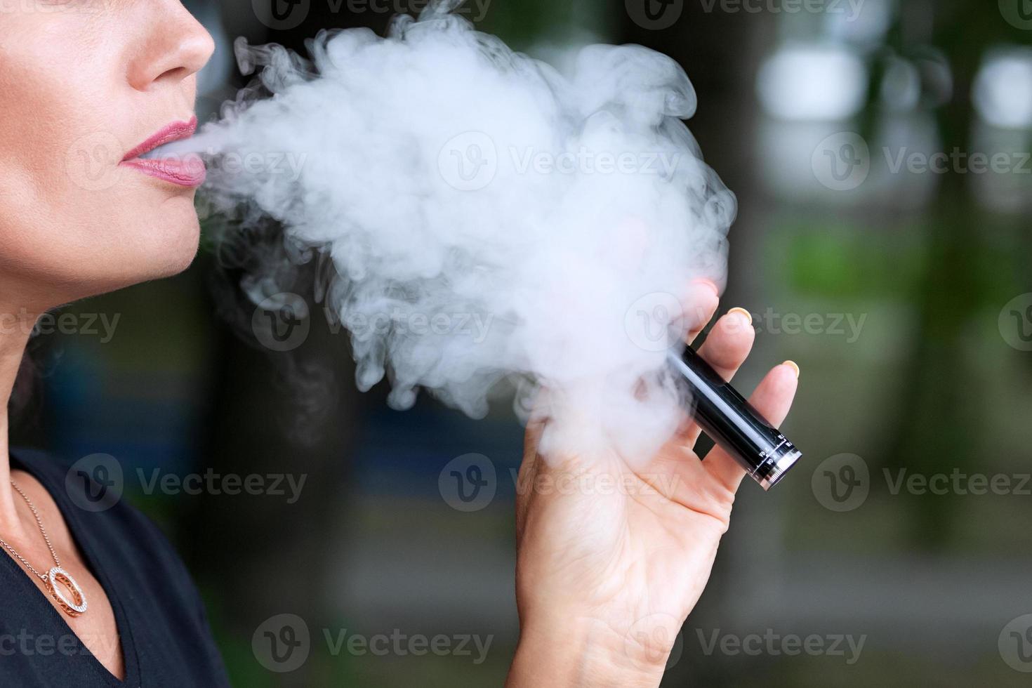 vrouw met een elektronisch sigaret, vapen foto