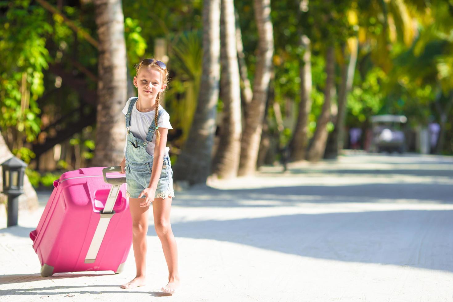 meisje dat roze bagage trekt foto