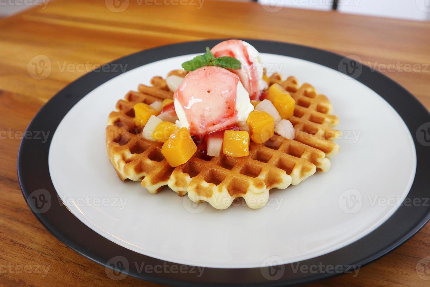 een bord van wafel ijs room Aan een cafe tafel foto