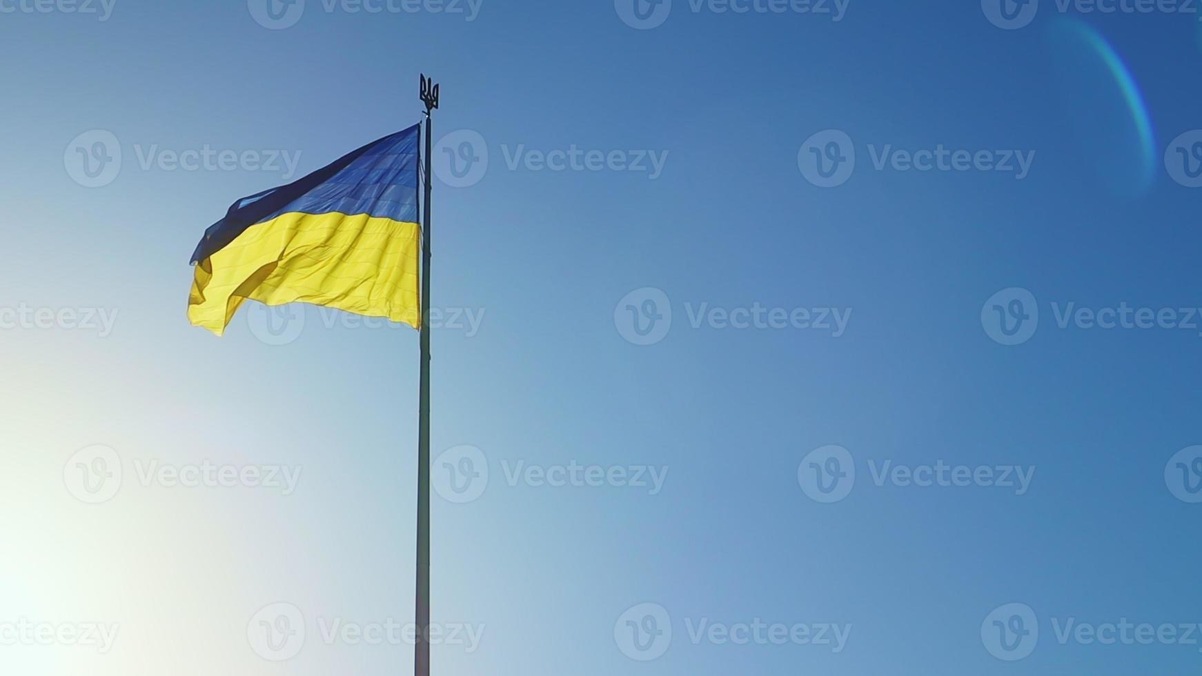 langzaam beweging vlag van Oekraïne golvend in de wind tegen een lucht zonder wolken Bij dageraad van de dag. oekraïens nationaal symbool van de land is blauw en geel. vlag lus met gedetailleerd kleding stof textuur. foto