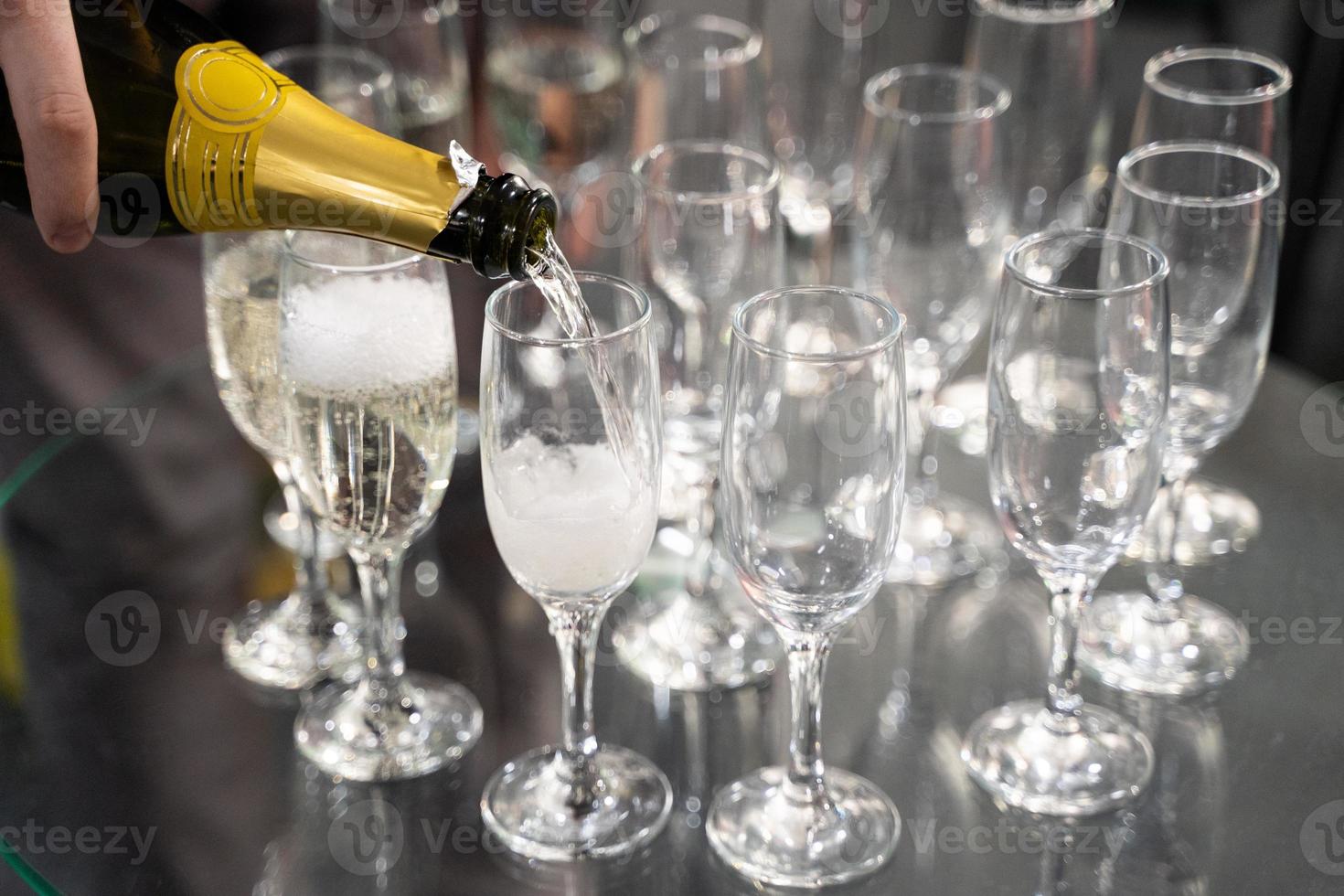 barman giet Champagne in een glas foto