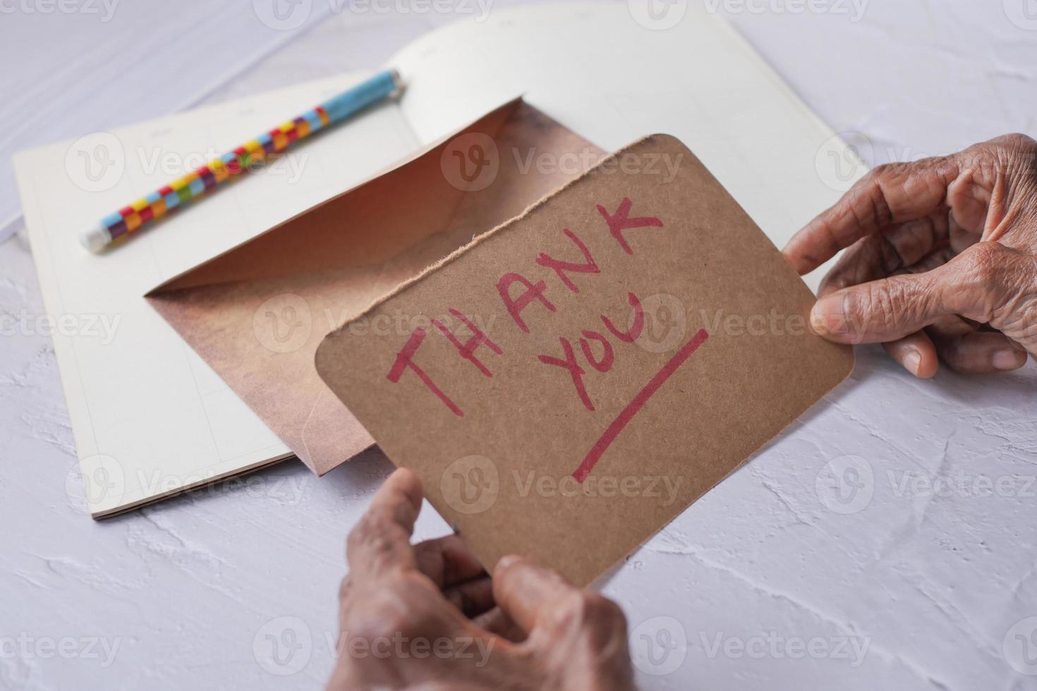 senior vrouwen hand- Holding dank u brief , achterzijde visie foto