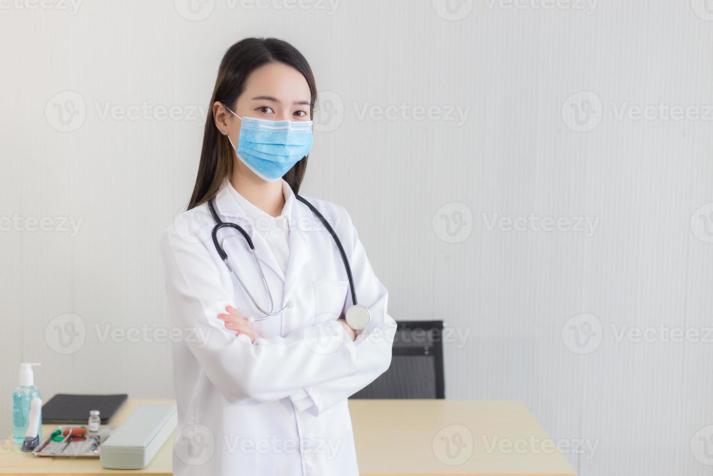Aziatisch vrouw dokter draagt een medisch gezicht masker foto
