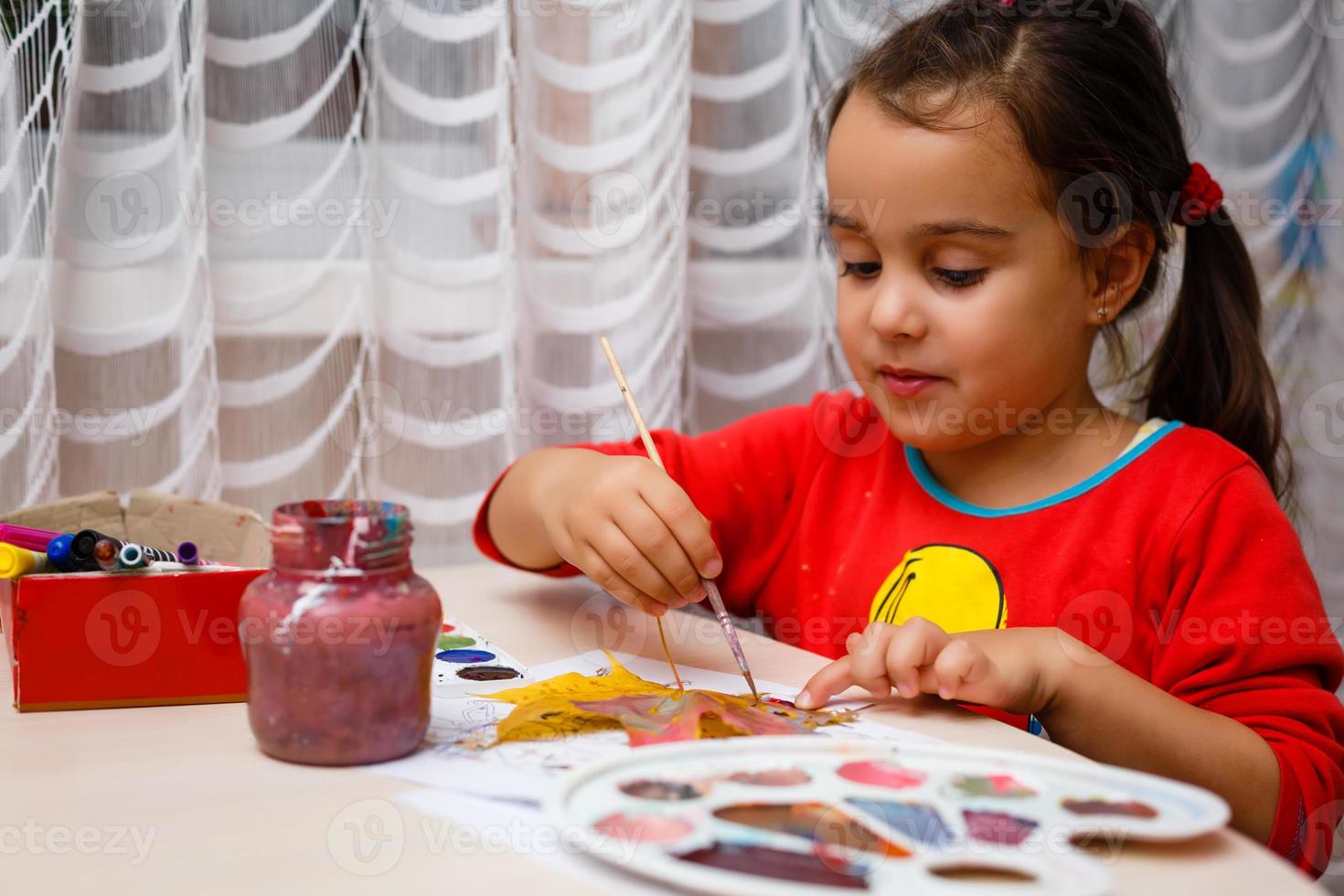 weinig meisje schilderij Aan herfst geel bladeren met gouache kinderen kunsten kinderen creativiteit herfst kunst foto