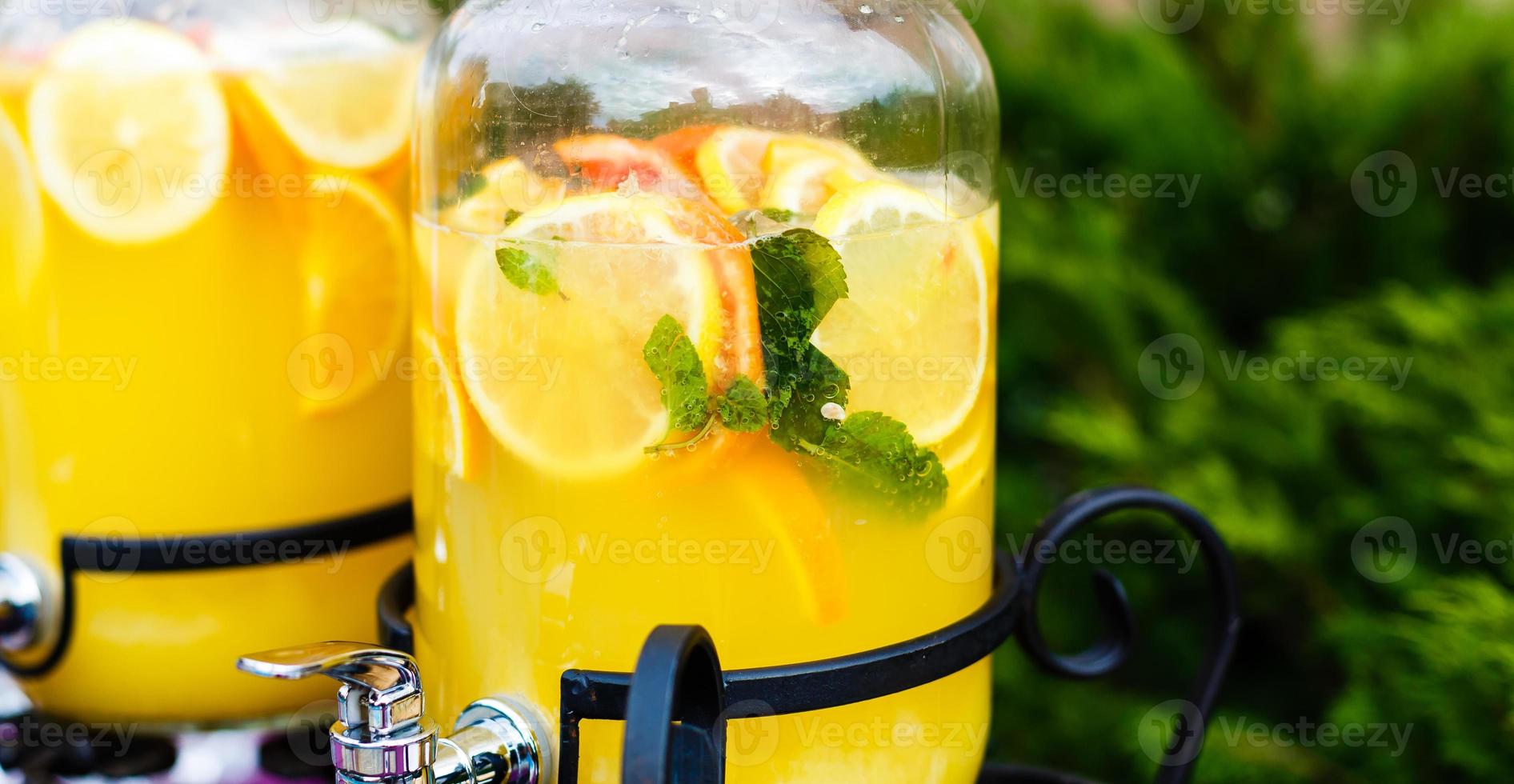 verkoudheid en verfrissend citrus fruit limonade in metselaar potten met oranje , limoen en citroen foto