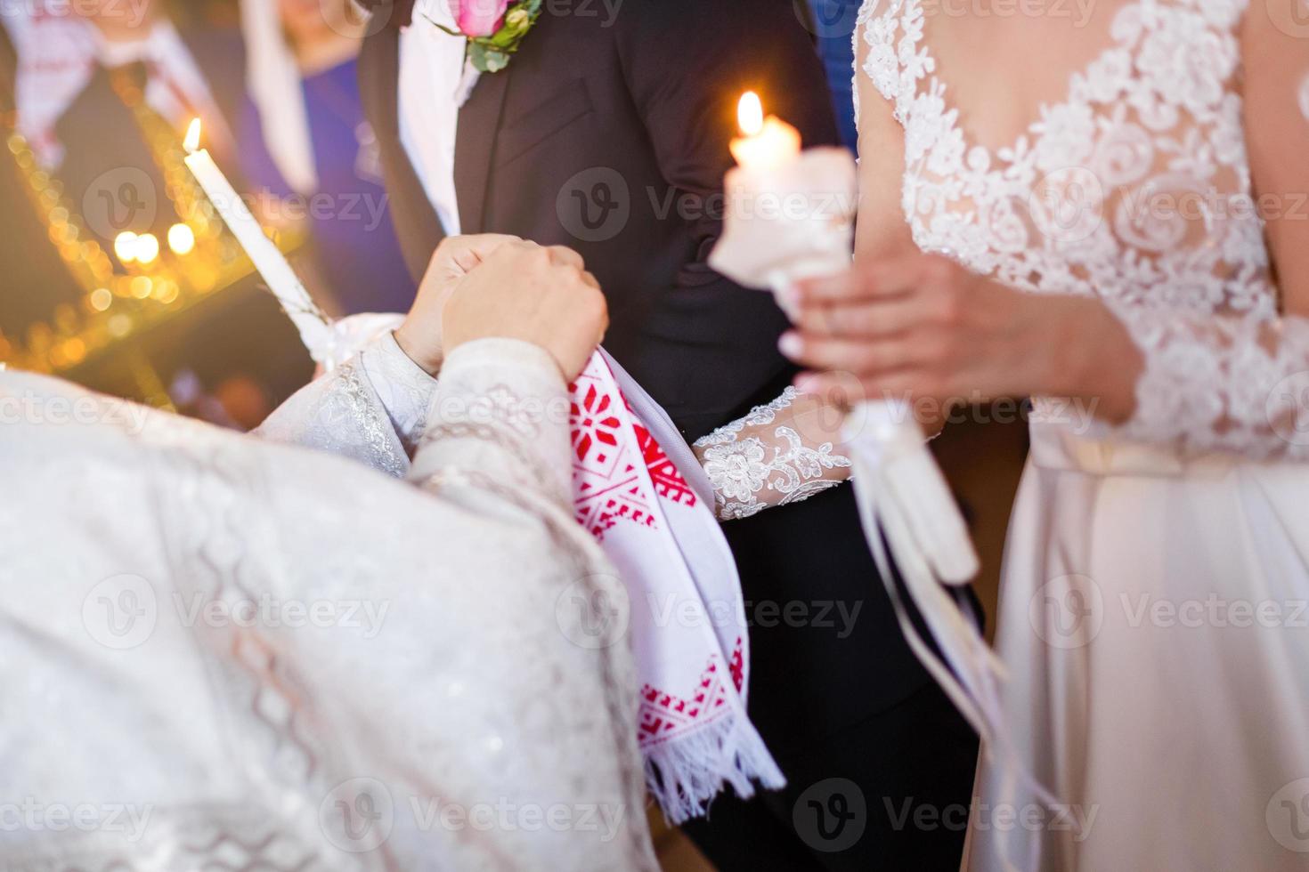 de priester zetten een ring Aan bruidegom vinger gedurende traditioneel bruiloft in kerk foto